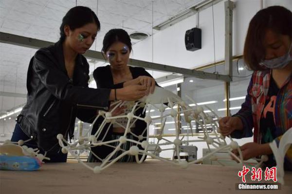 4月11日,在武汉纺织大学服装与服饰设计专业毕业作品展上,3套用3D技术打印而成的服装作品一经亮相,引来不少关注。据设计者汤晓介绍,该服装以希腊神话故事里海妖Siren为灵感而创作,3D服装立体呈现出了海妖的骨骼结构。服装从设计到成型用时4个月,耗资5万余元。图为组装3D服装。